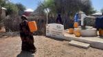 Owliya carries water home from the well. 